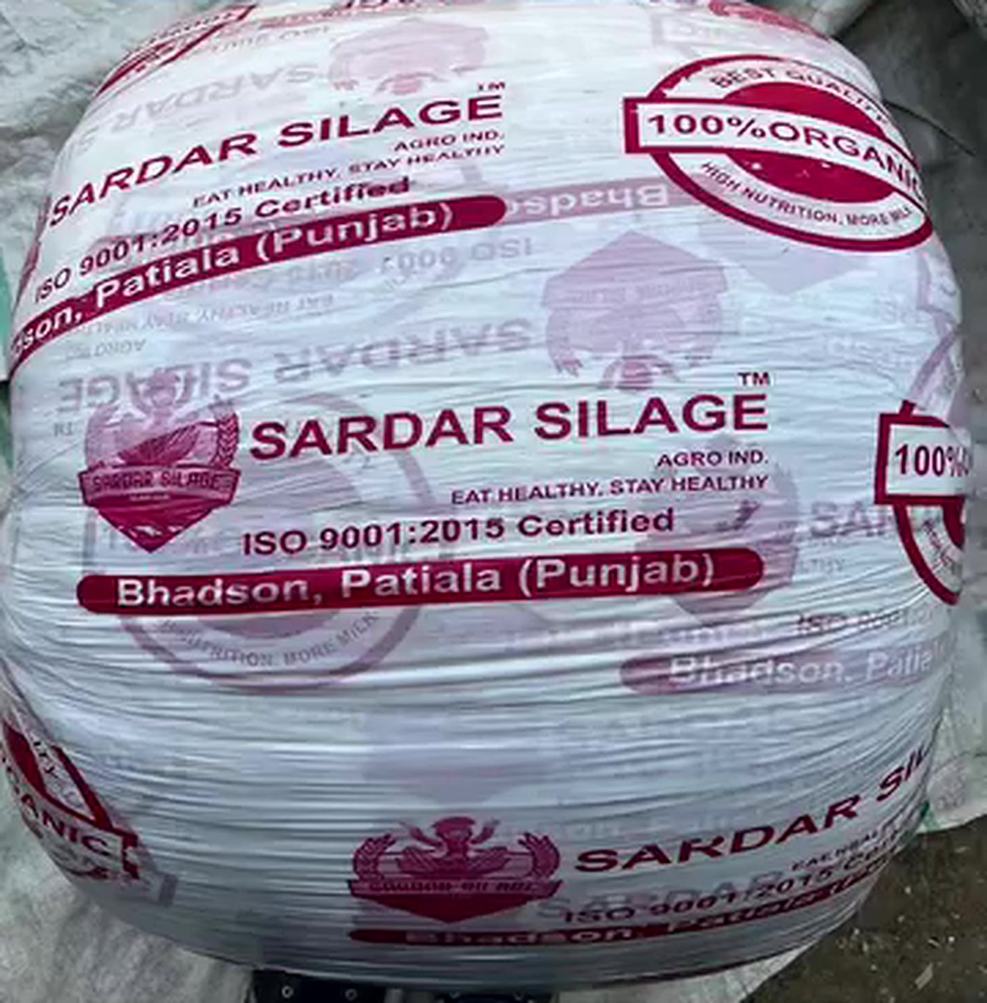A wrapped Sardar Silage bale with our pink print: Sardar Silage name, 100% Organic seal, ISO 9001:2015 Certified mark and Bhadson, Patiala (Punjab) address